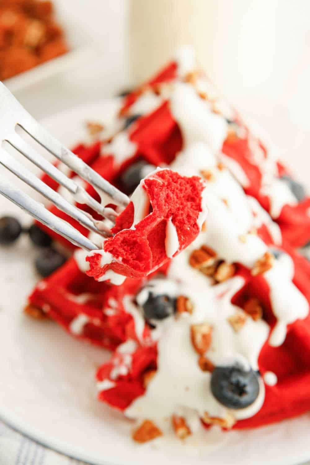 red velvet waffle piece on the tines of a fork.