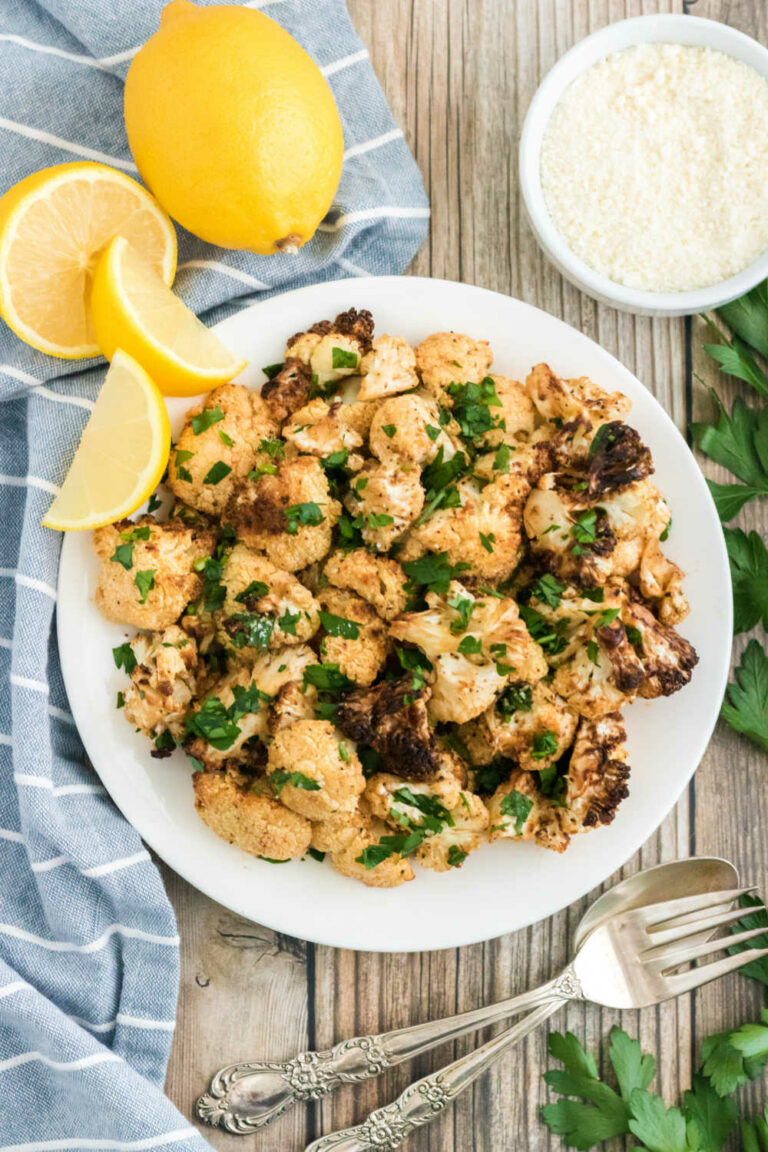 The recipe on a white plate with lemon wedges.