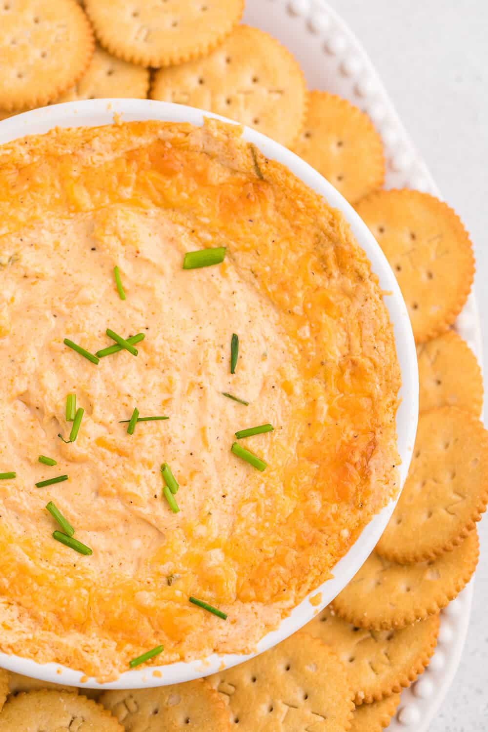 Crab dip on platter surrounded by crackers.