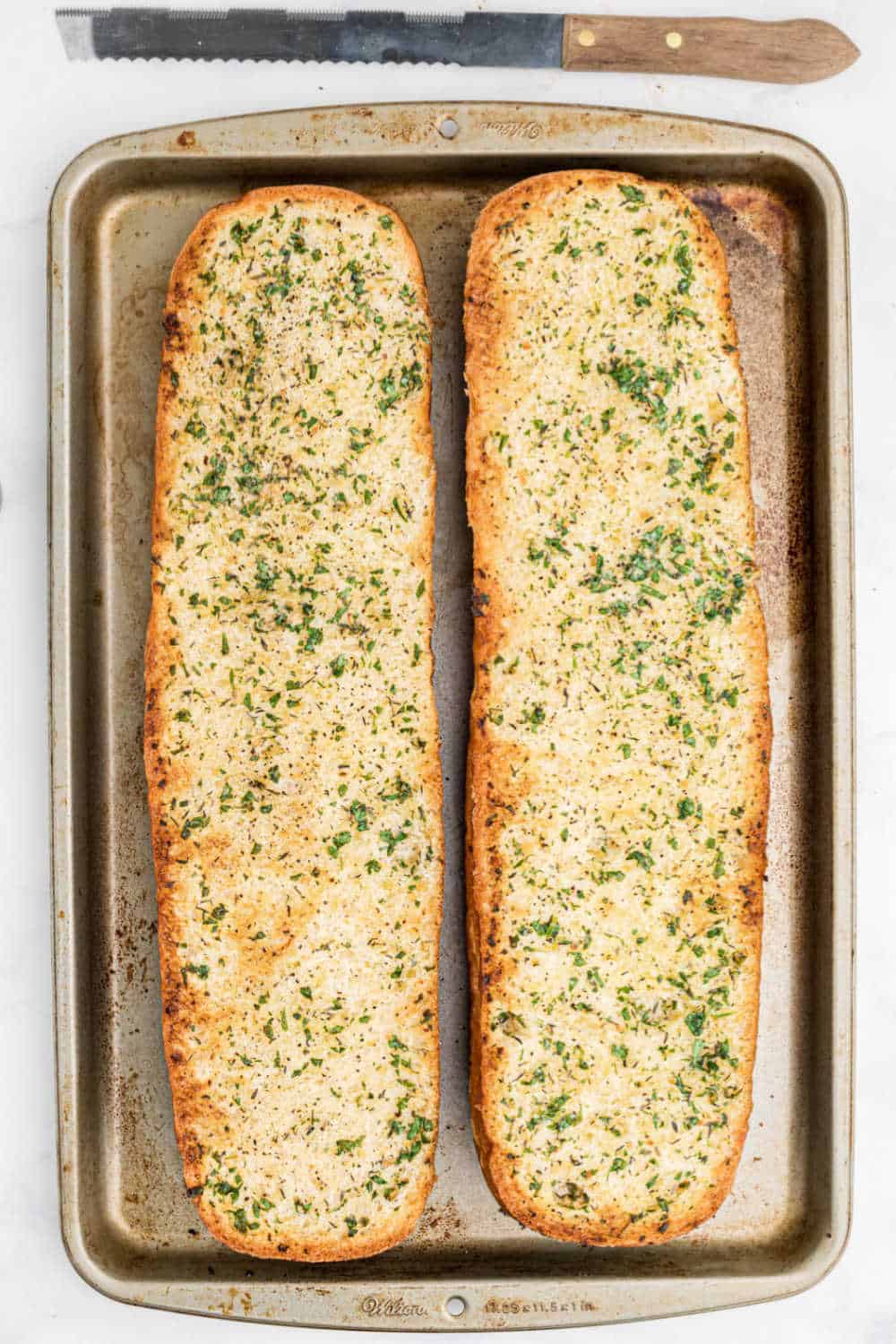 A loaf of garlic bread on a baking sheet.