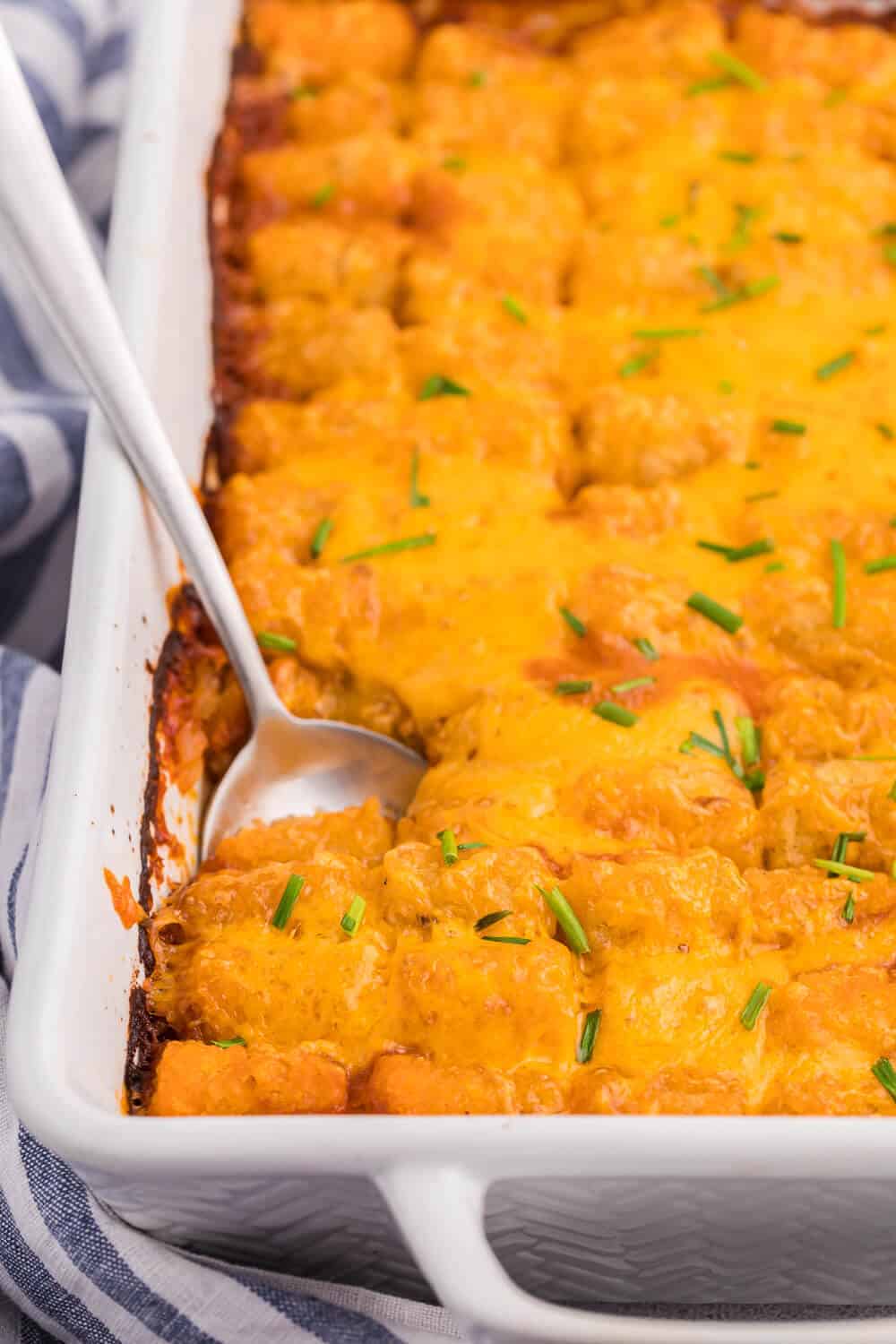 Sloppy Joe Tater Tot Casserole in a baking dish with a serving spoon.