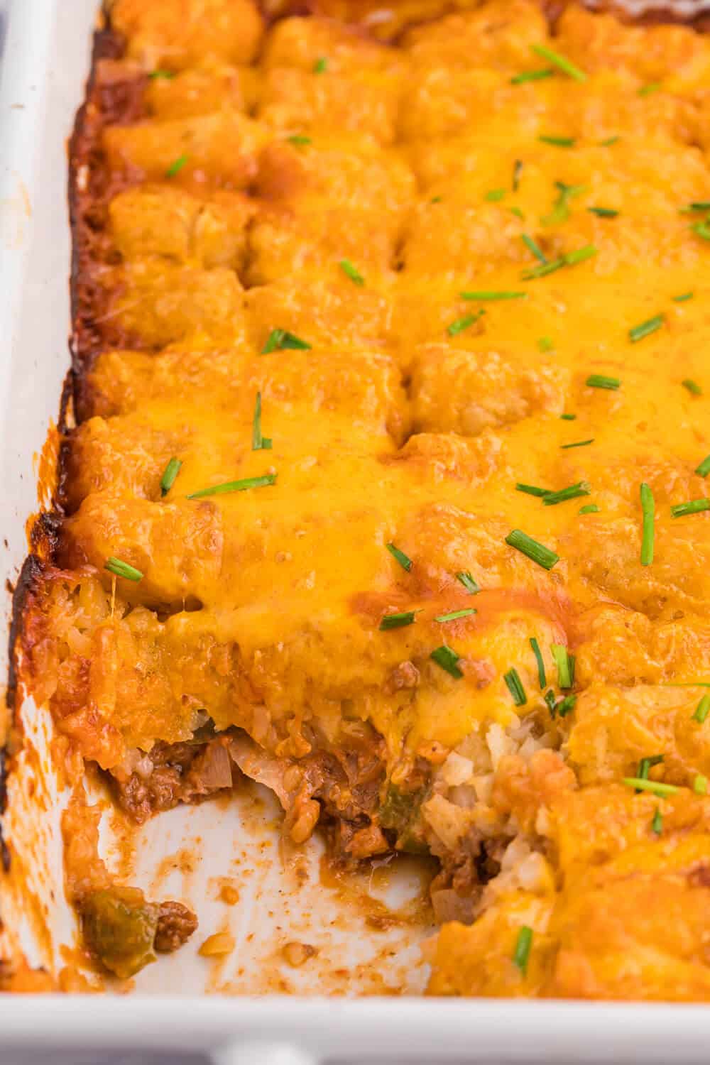 Sloppy Joe Tater Tot Casserole in a casserole dish with a serving removed.