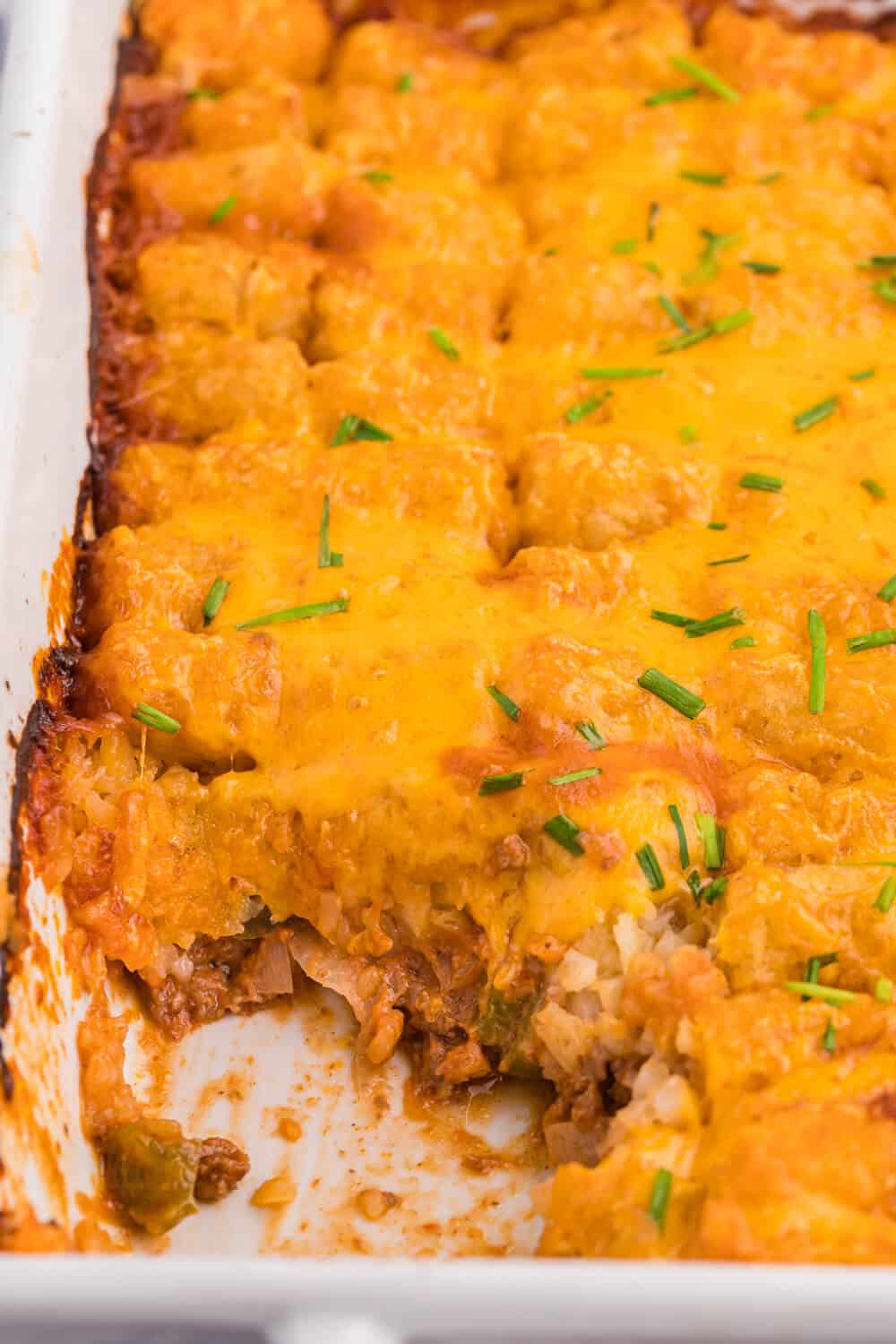 Sloppy Joe Tater Tot Casserole in a casserole dish with a serving removed.