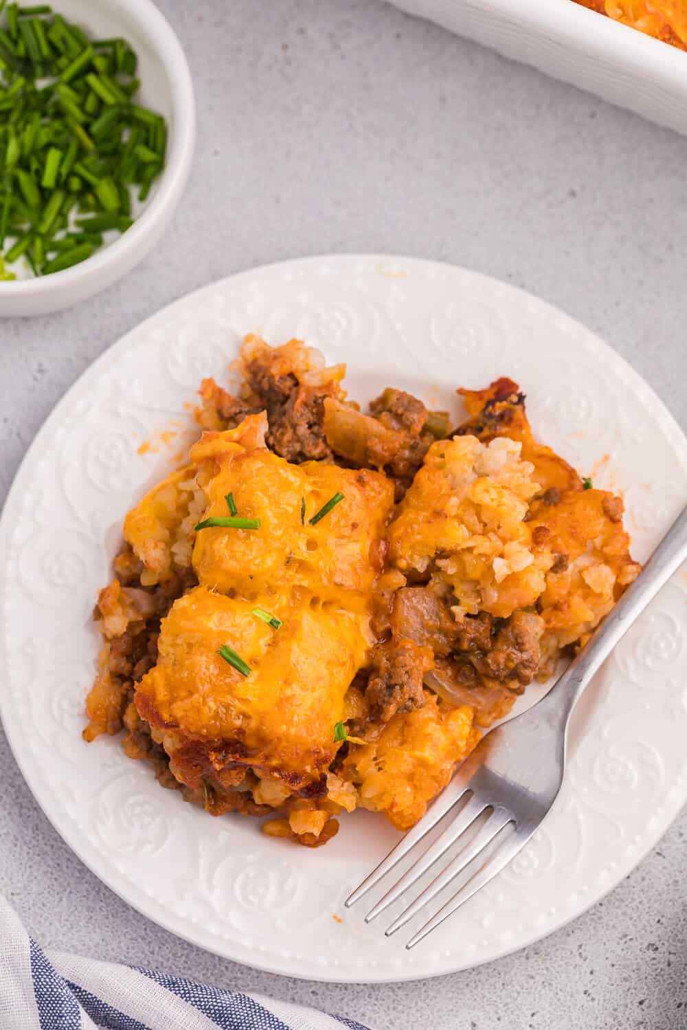 Sloppy joe tater tot casserole served on a plate with a fork.