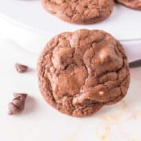A cookie leaning up against a plate.