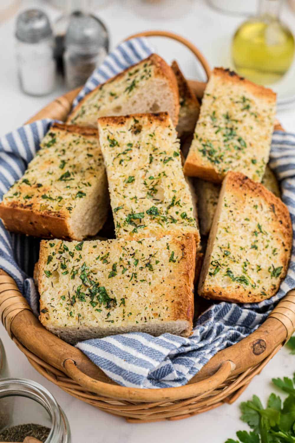 Pieces of garlic bread in a brown wicker basket.