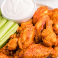 The recipe on a plate with celery sticks and ranch dip.