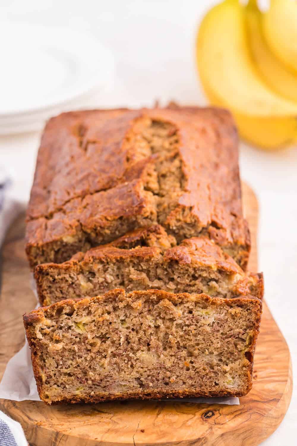 A loaf of banana bread with slices cut at the end.