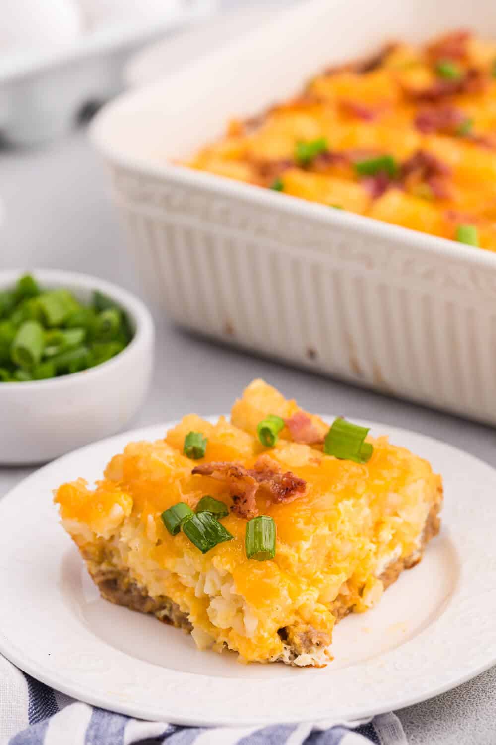 A slice of tater tot breakfast casserole served on a plate.