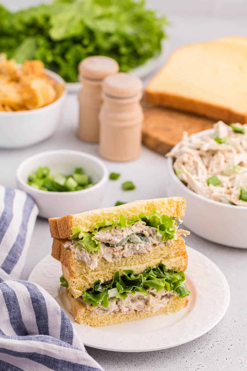 A chicken salad sandwich stacked on a plate.