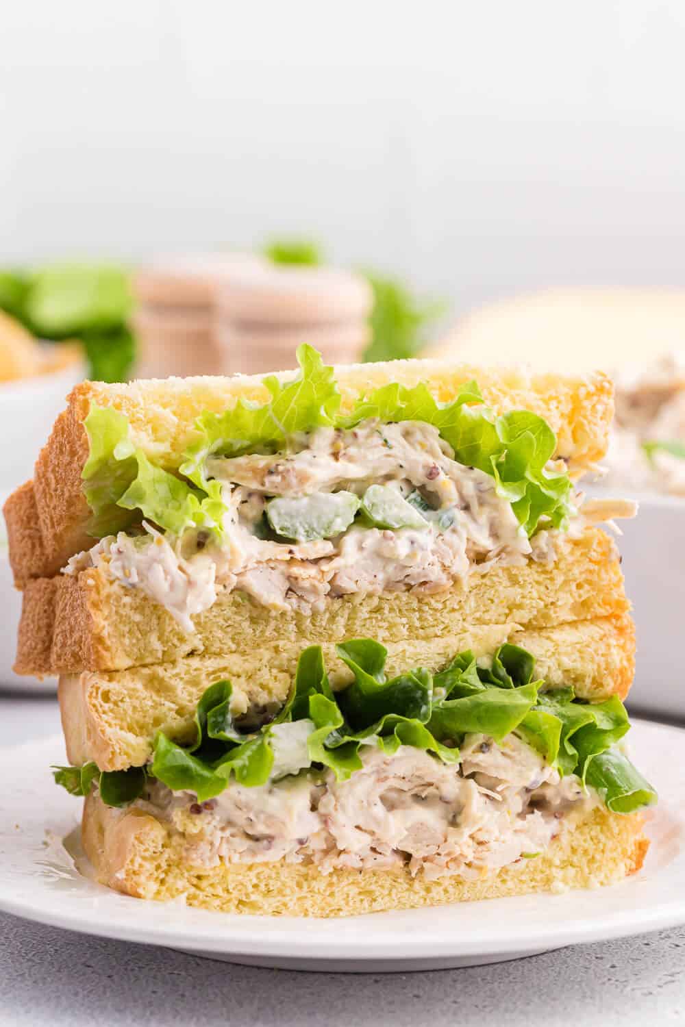 A stack of chicken salad sandwiches on a plate.