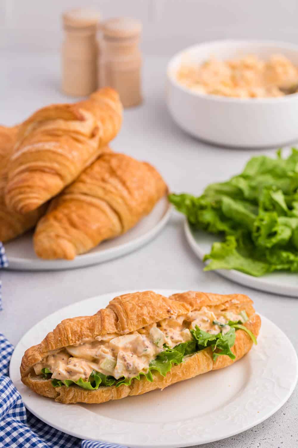 Egg salad on a croissant with lettuce.