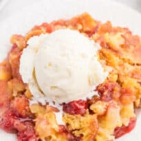 A piece of the recipe topped with vanilla ice cream on a plate.