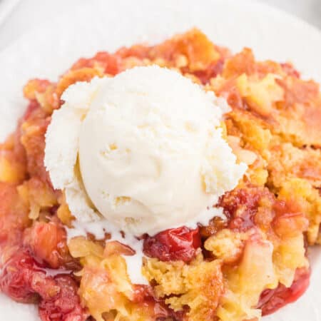 A piece of the recipe topped with vanilla ice cream on a plate.