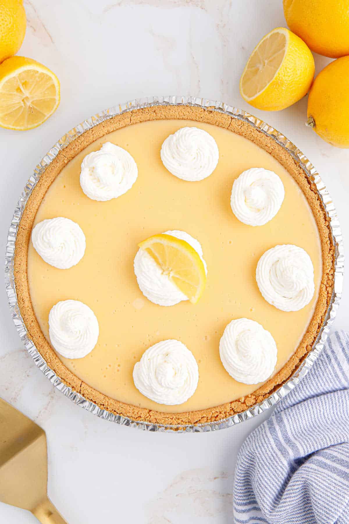 A classic lemon pie garnished with whipped cream and a lemon slice.