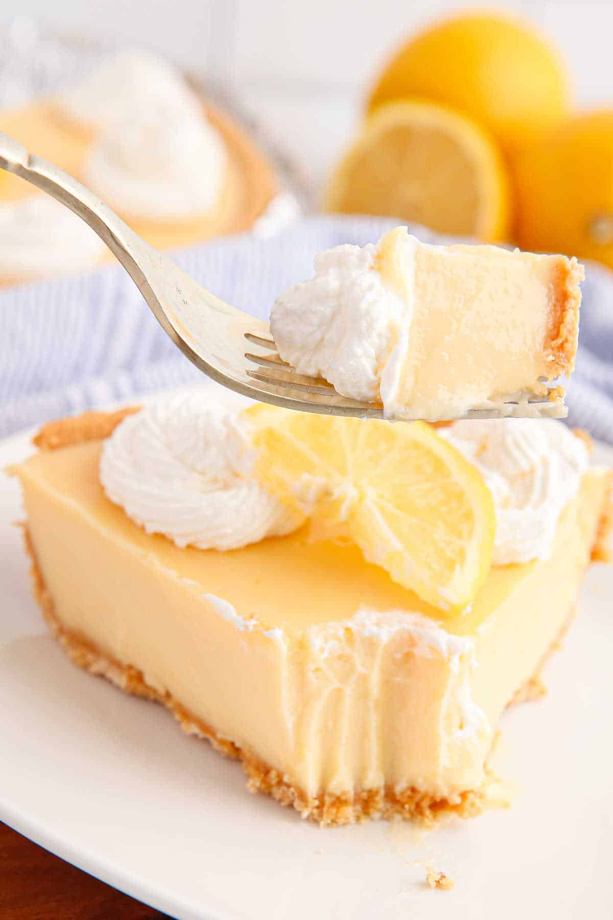 A bite of classic lemon pie on a fork.