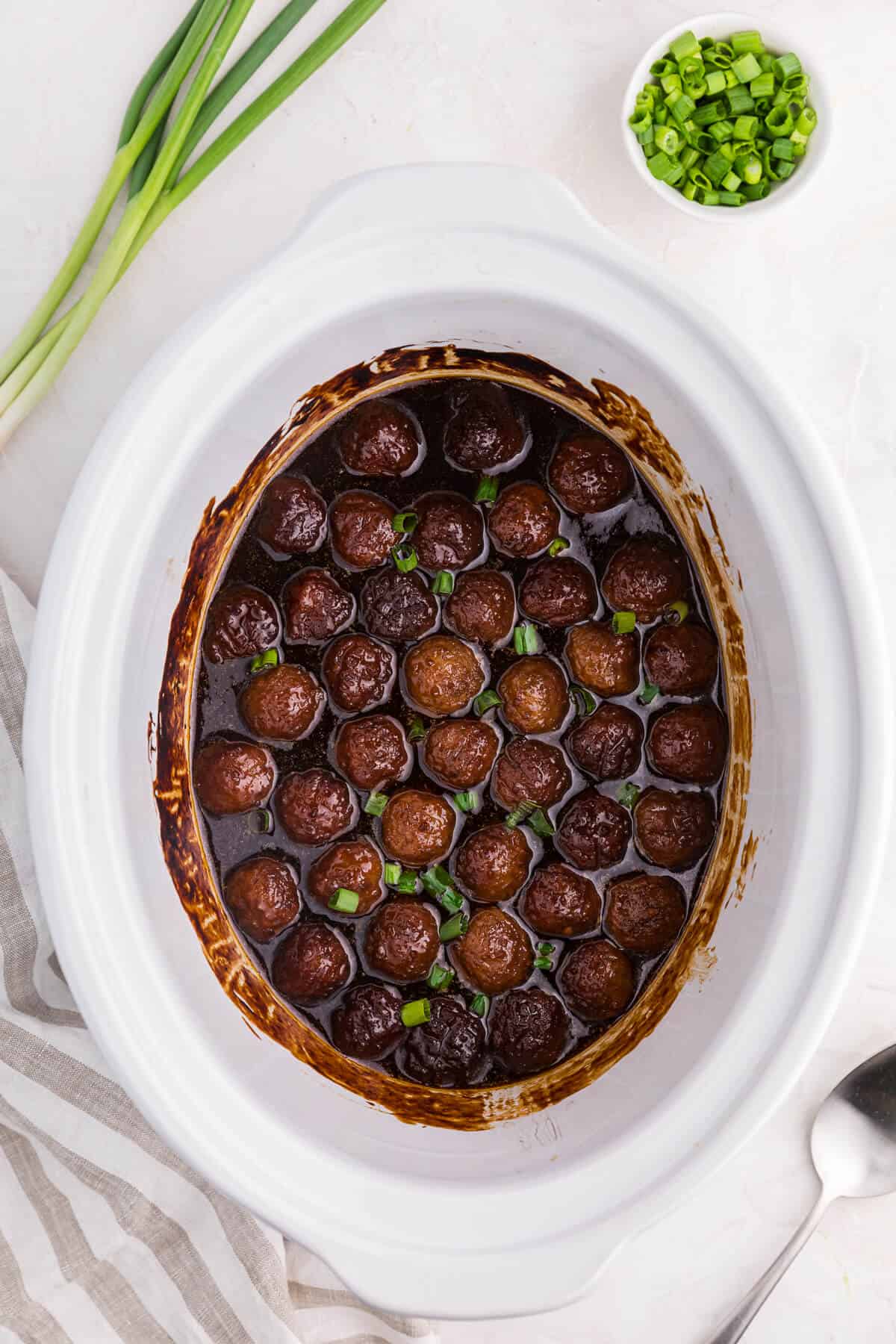 Grape jelly meatballs in a white crockpot.