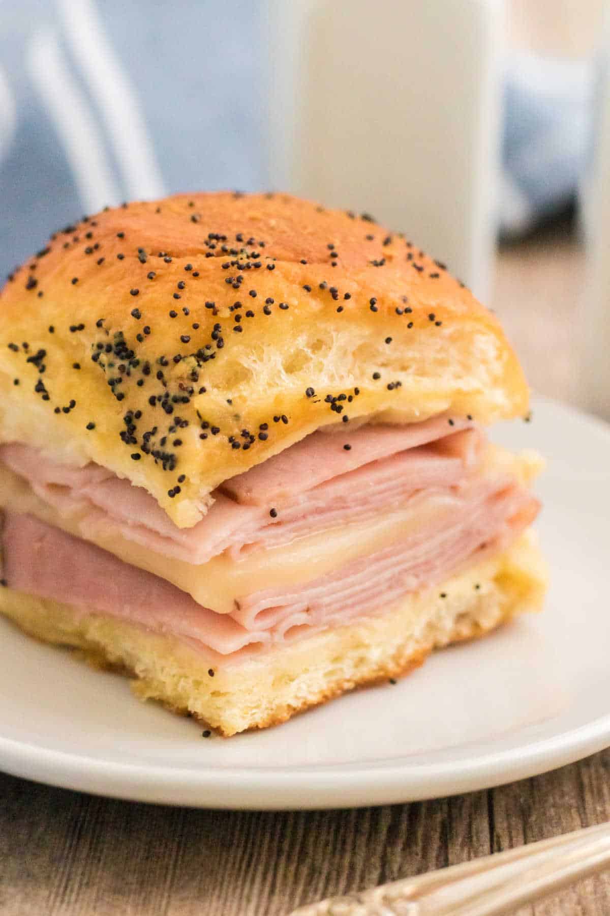 A ham and cheese slider on a white plate.