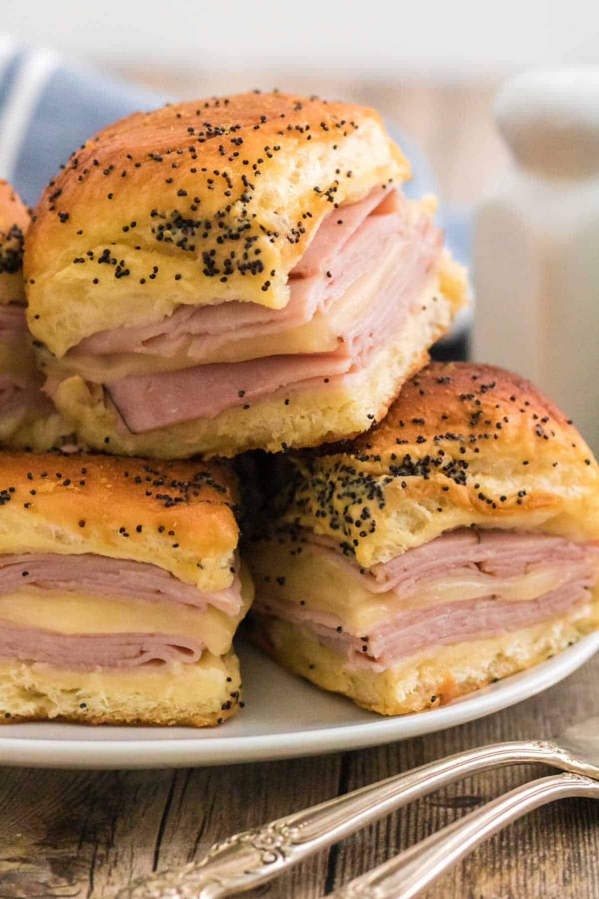 Ham and cheese sliders piled on a plate.