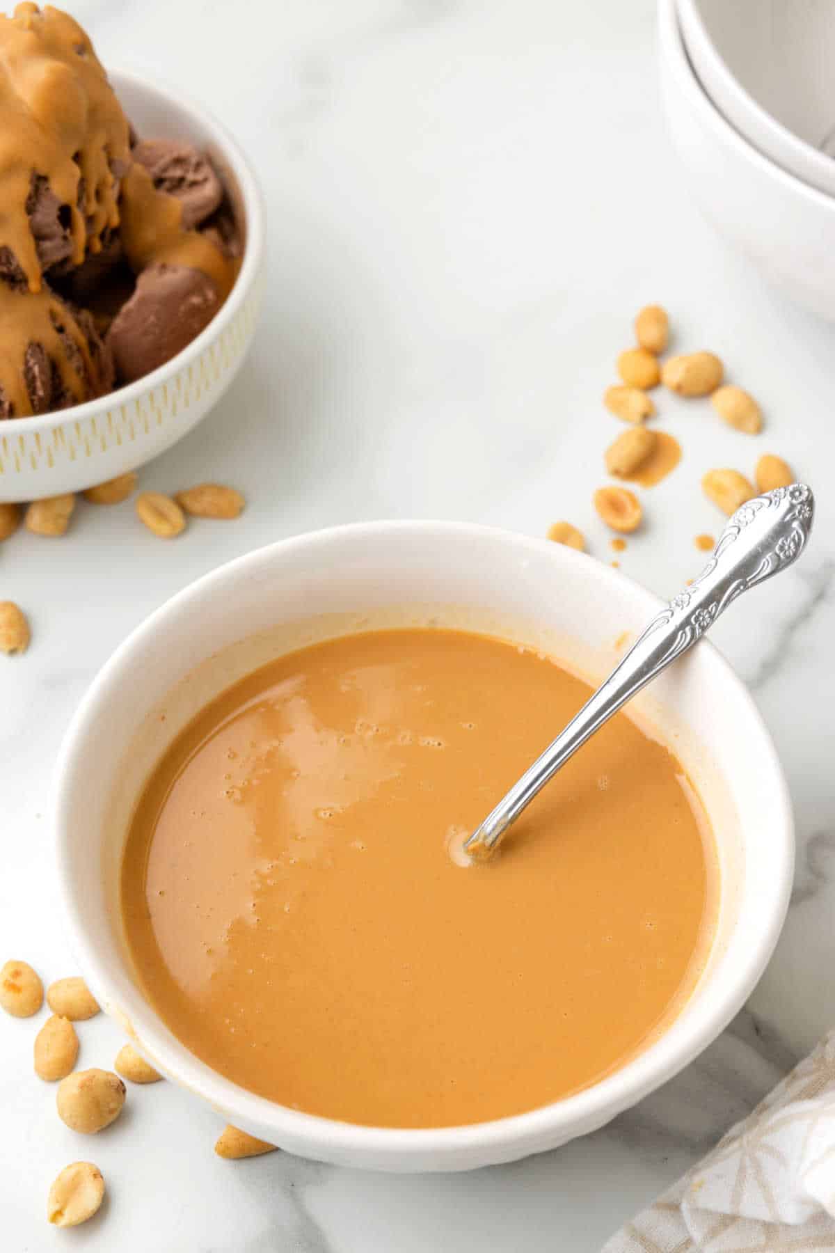 Peanut butter magic shell in a bowl with a spoon.