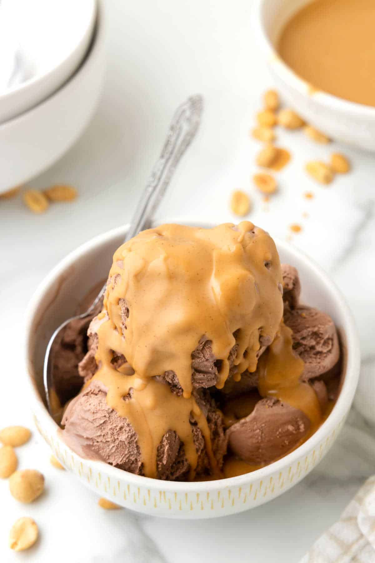 Peanut butter magic shell on chocolate ice cream in a white bowl.