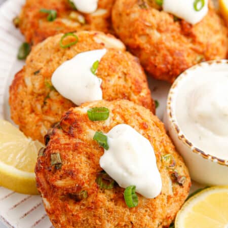 The recipe on a plate with lemon and tartar sauce.