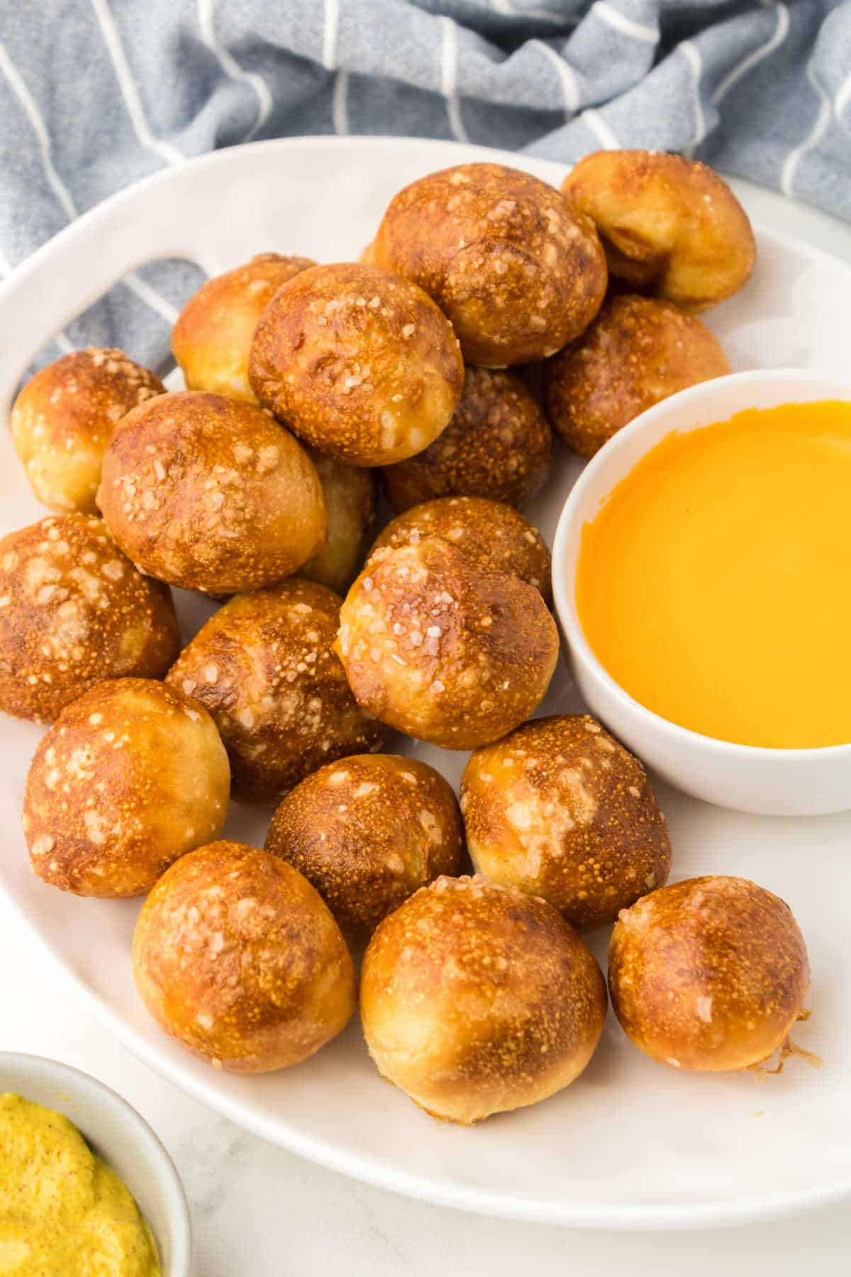 A plate of pretzel bites and cheese sauce.