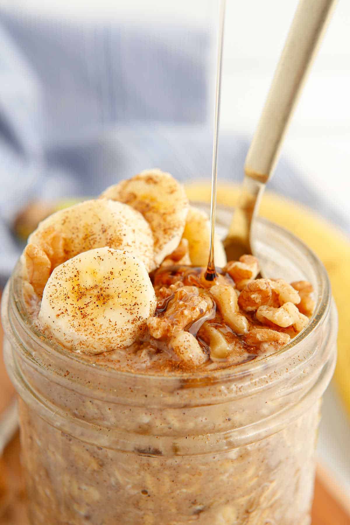 Banana bread overnight oats in a mason jar with maple syrup drizzled on top.