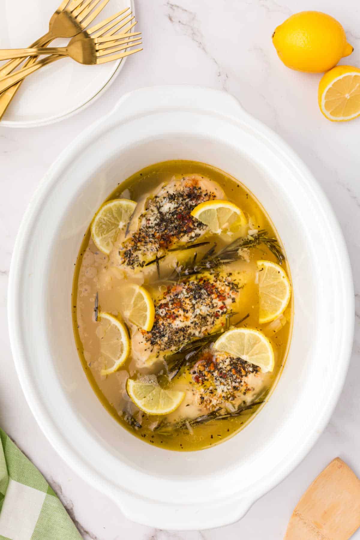 Lemon garlic butter chicken in a white slow cooker.