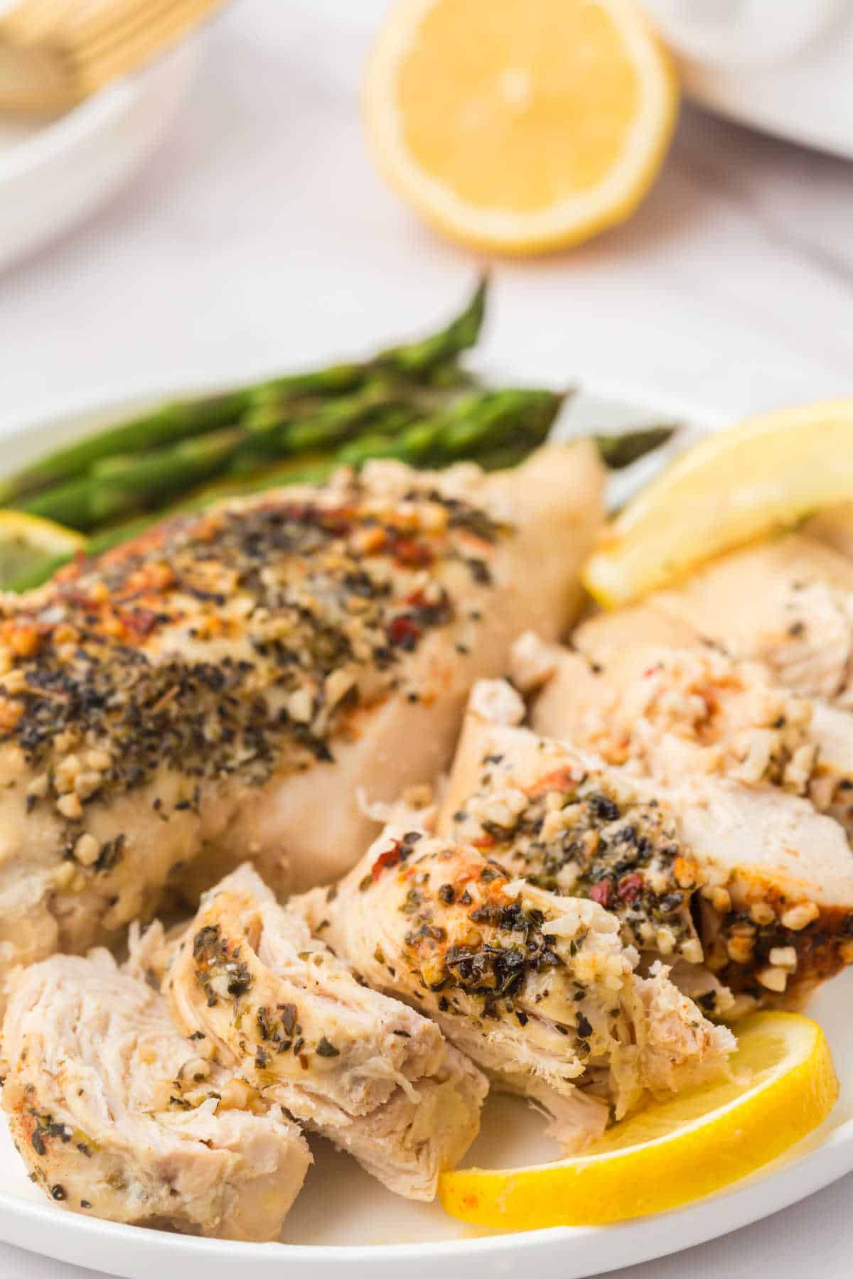 Crockpot lemon garlic butter chicken sliced on a plate.