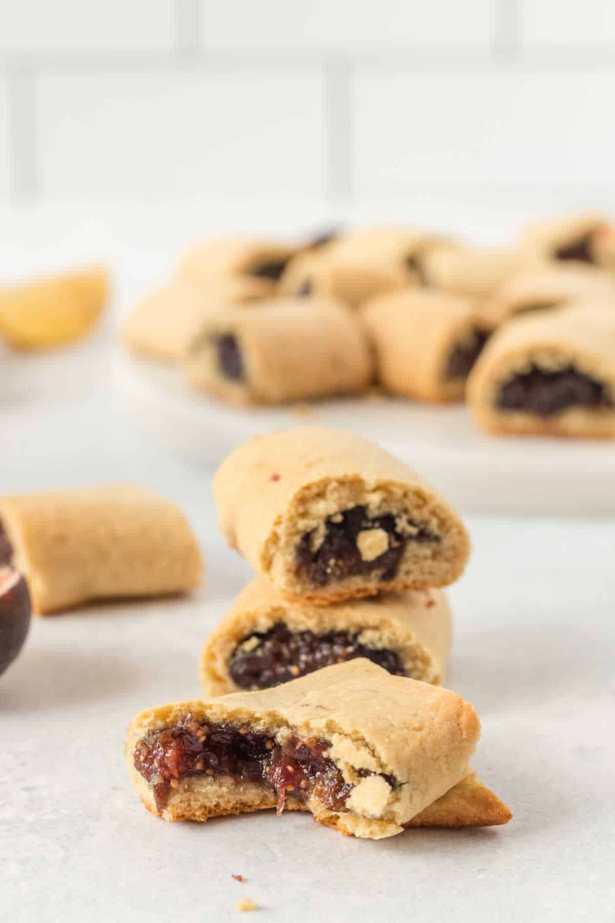 A stack of cookies with a cookie in front with a bite out of it.