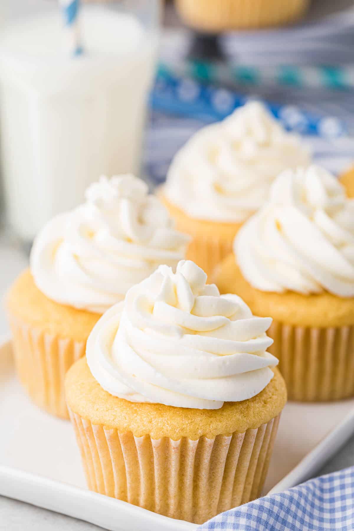 Stabilized whipped cream on top of vanilla cupcakes.