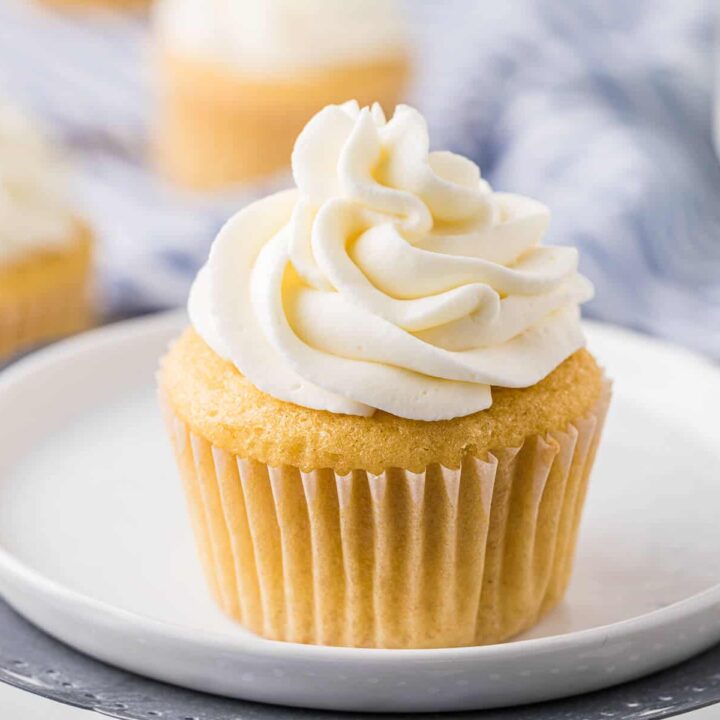 Stabilized whipped cream on top of a vanilla cupcake.