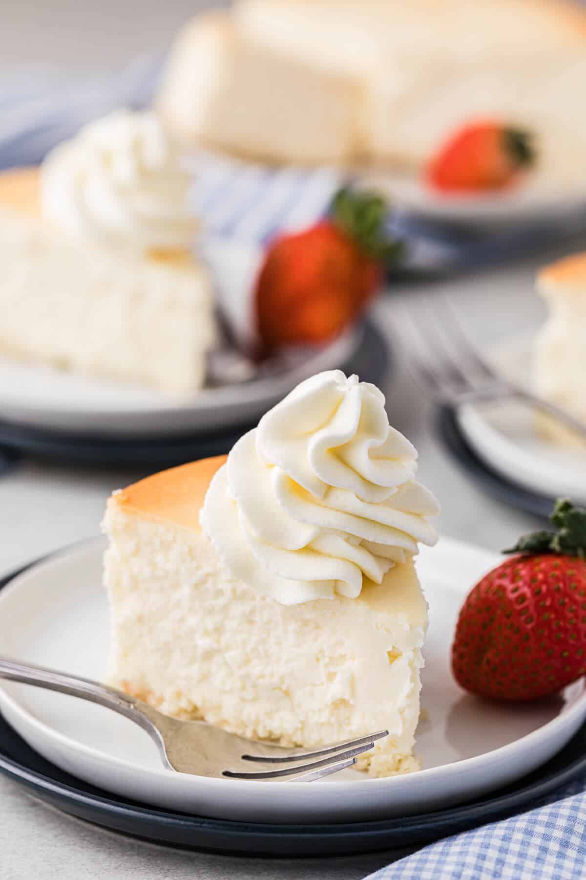 Stabilized whipped cream on top of a slice of cheesecake.