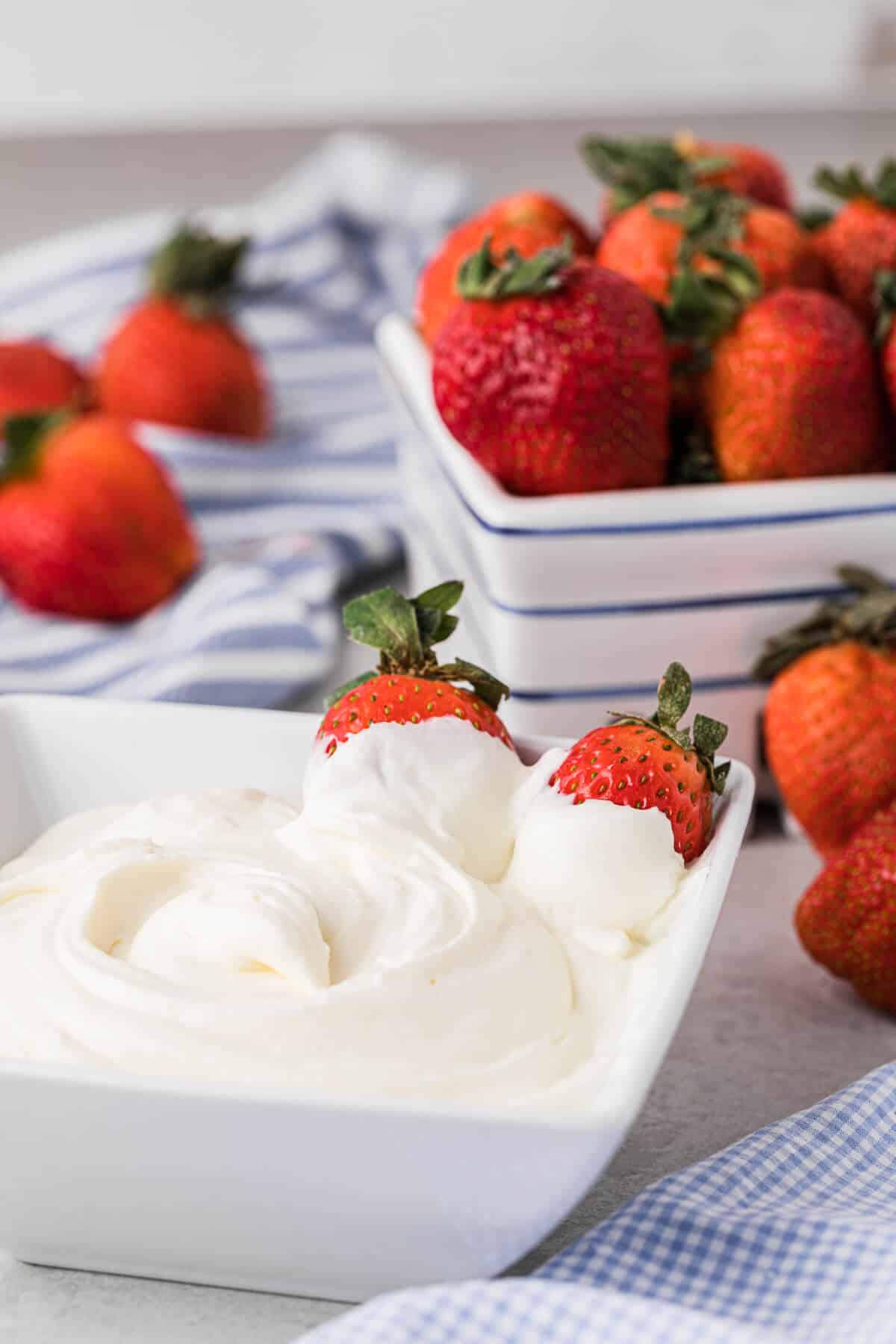 A bowl of stabilized whipped cream with strawberries in it.