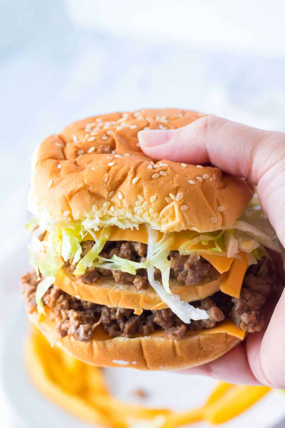 A hand holding a big mac sloppy joe.