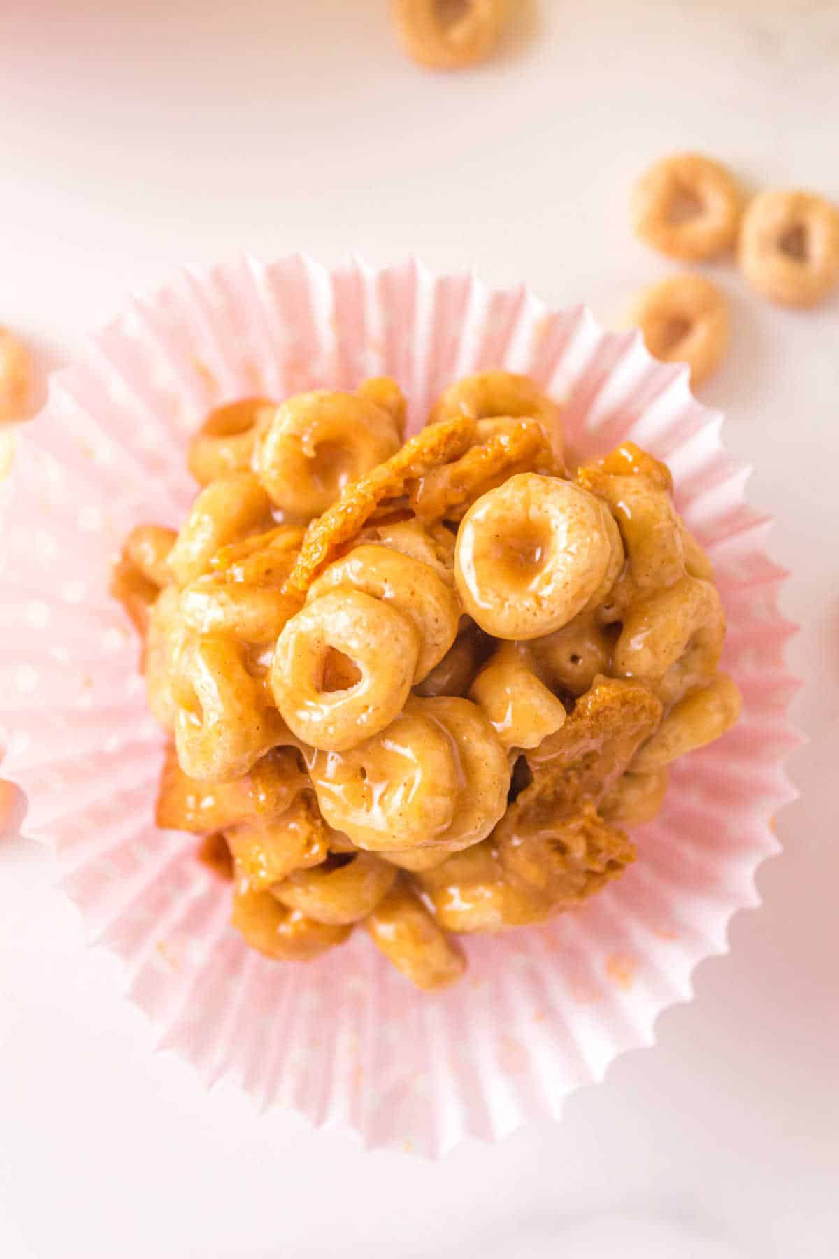 A peanut butter Cheerio balls in a pink cupcake liner.