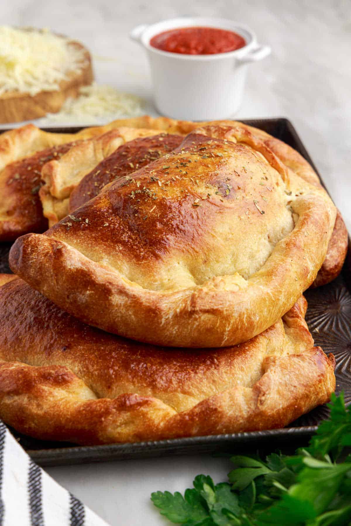 Meat calzones on a baking sheet.