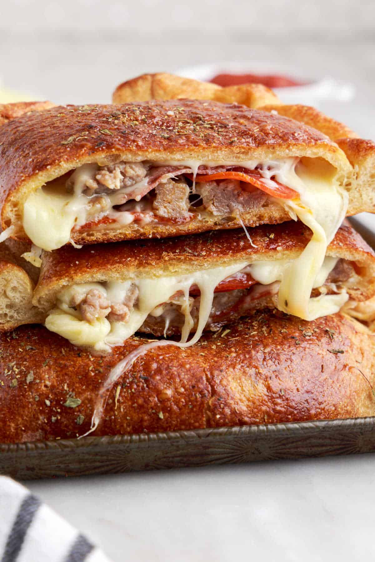 Meat calzone cut in half and piled on top of each other.