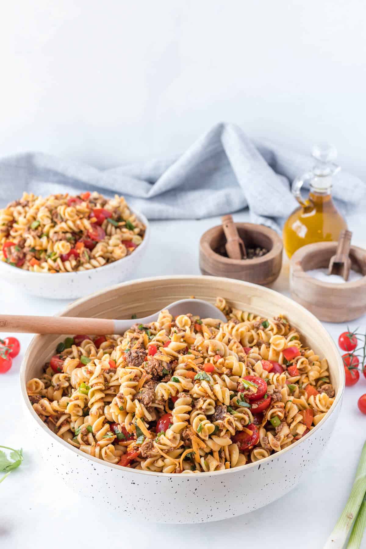 A bowl of taco pasta salad with a serving spoon.