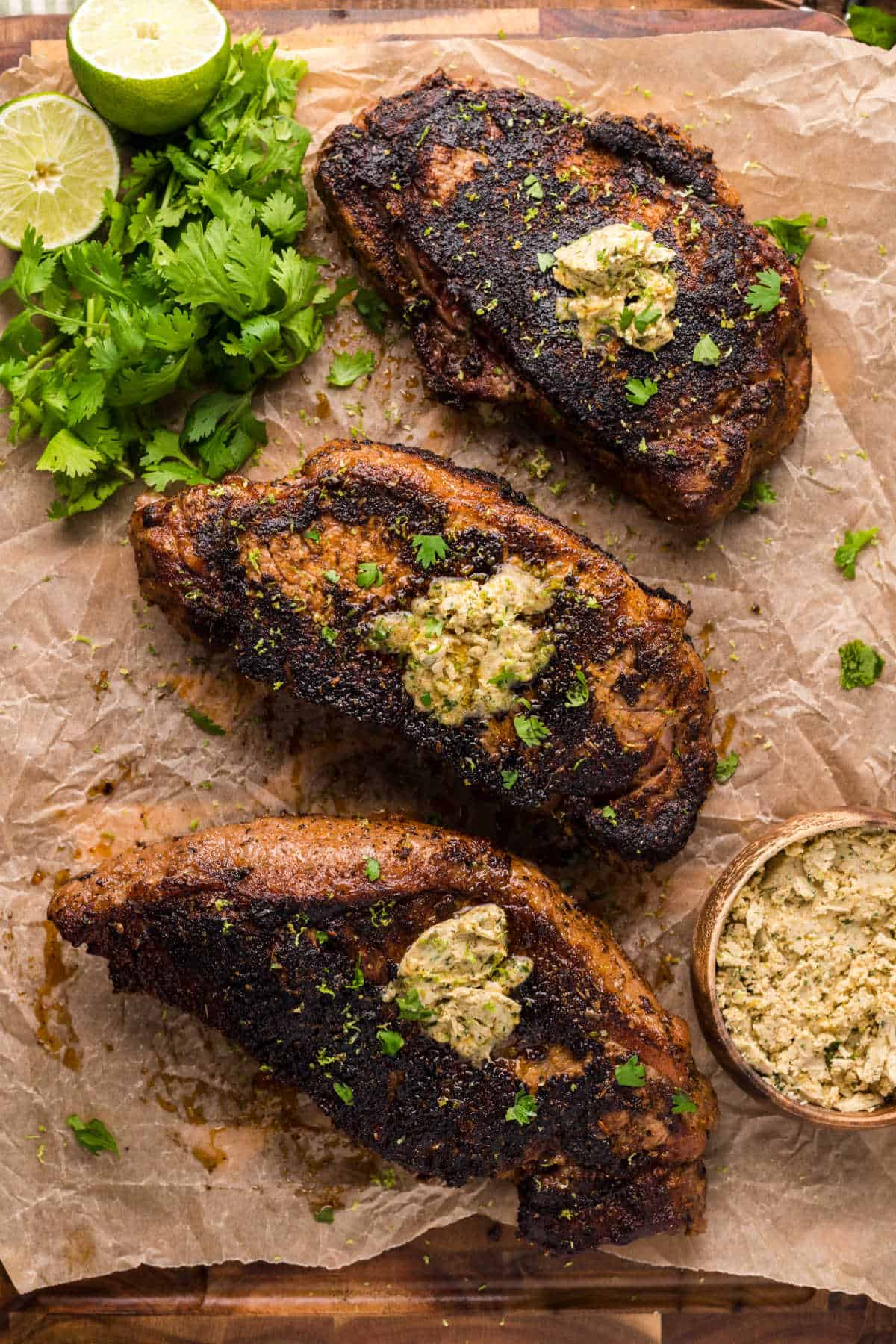 Blackened steaks on a piece of parchment paper.