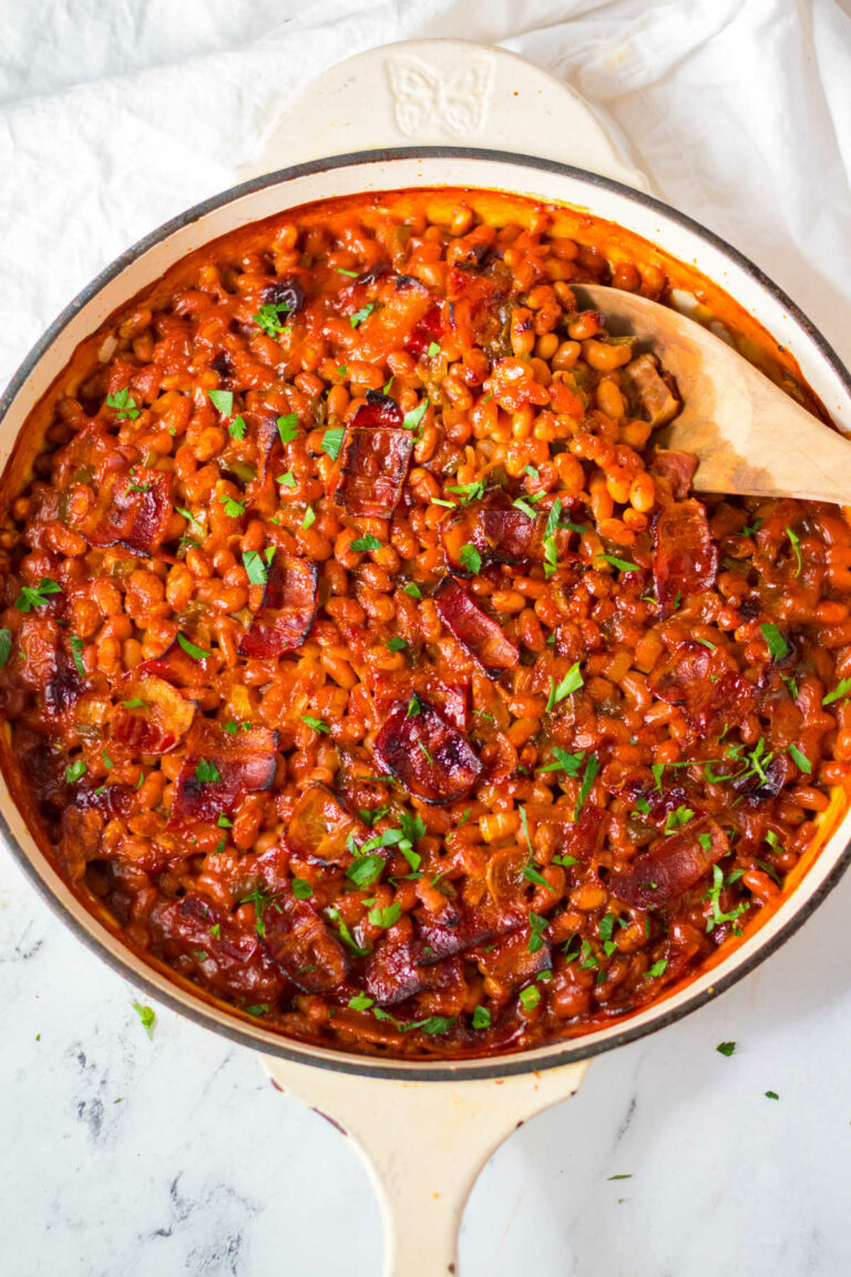 The beans in a skillet with a wooden spoon.