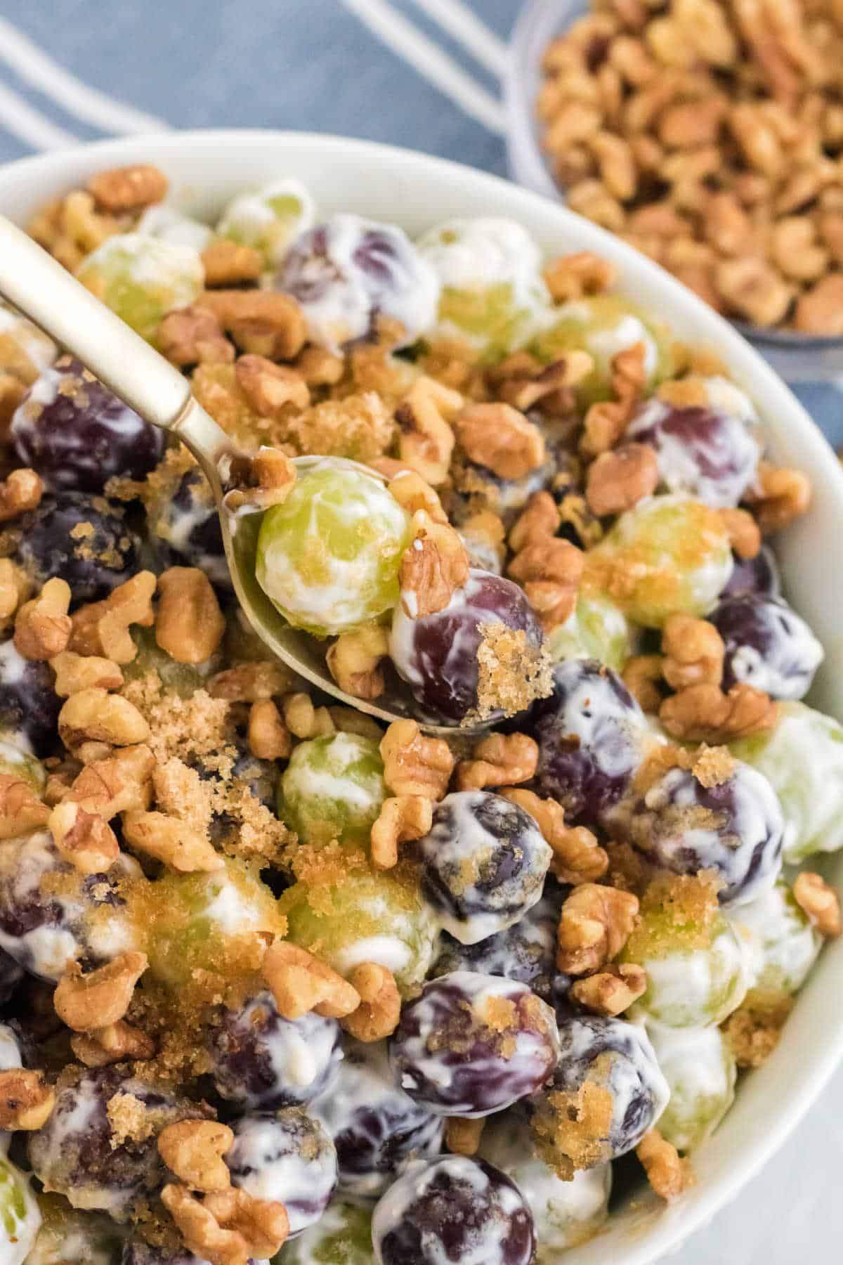 Grape salad in a bowl with a spoon.