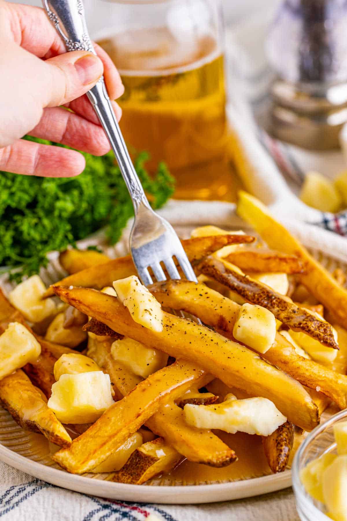 A fork put into a plate of poutine.