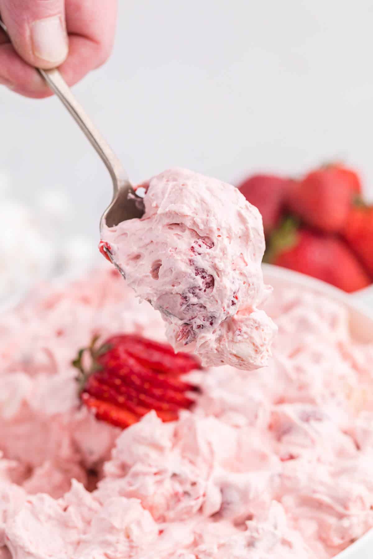 Strawberry fluff salad on a spoon.