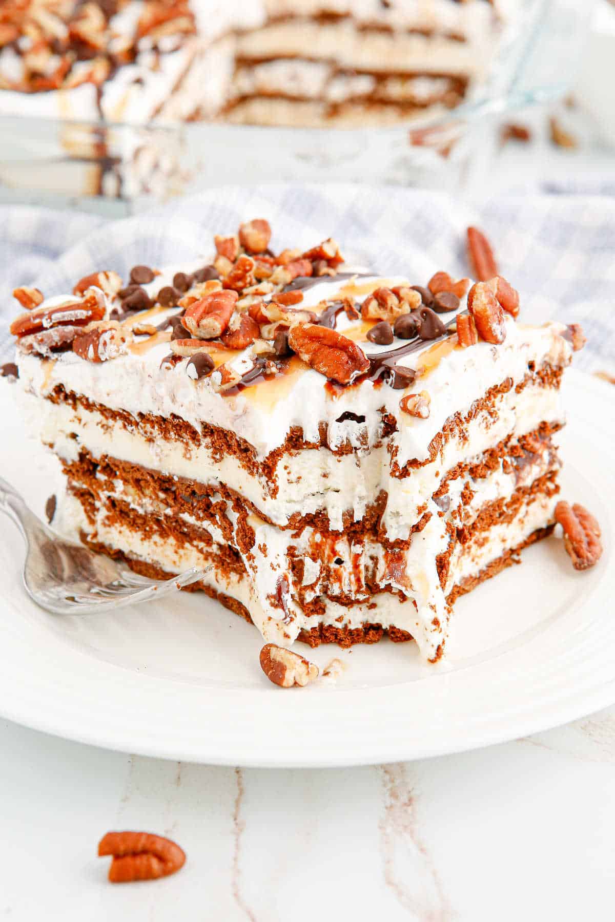 A slice of turtle ice cream sandwich cake on a plate with a bite out of it.