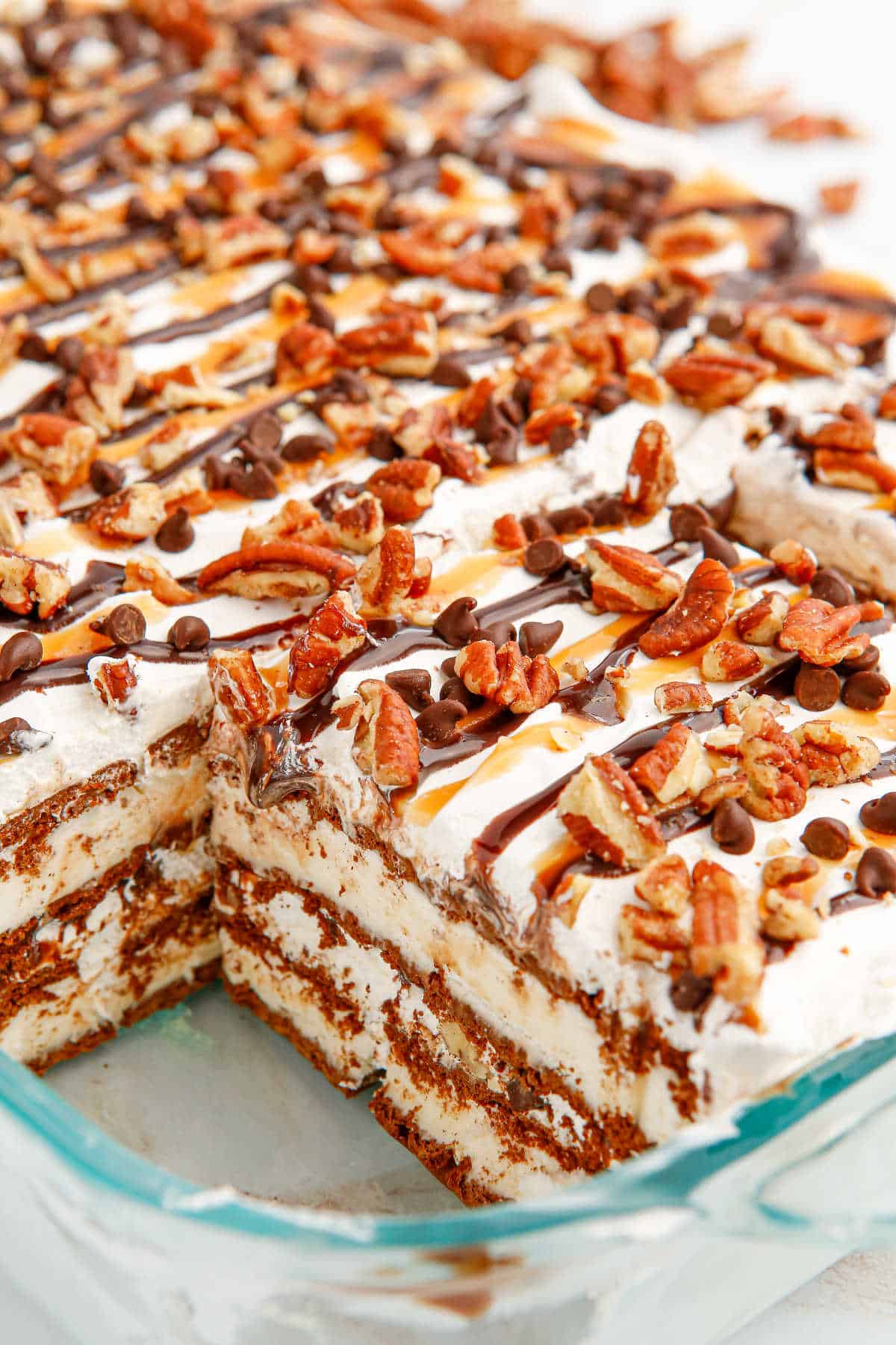 Turtle Ice Cream Sandwich Cake in the pan with a slice cut out.