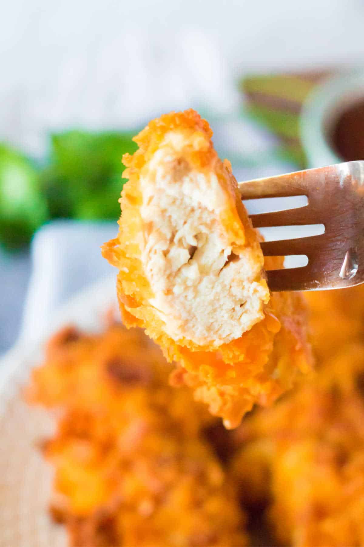 A piece of chicken tender on a fork.