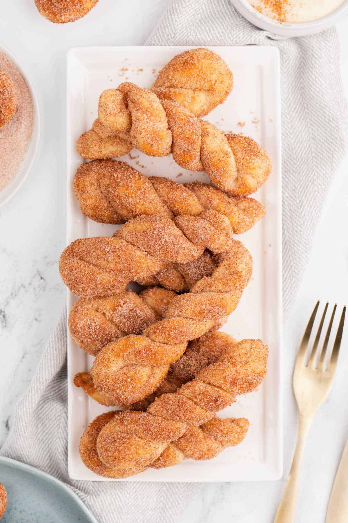 Air fryer cinnamon twists on a white platter.