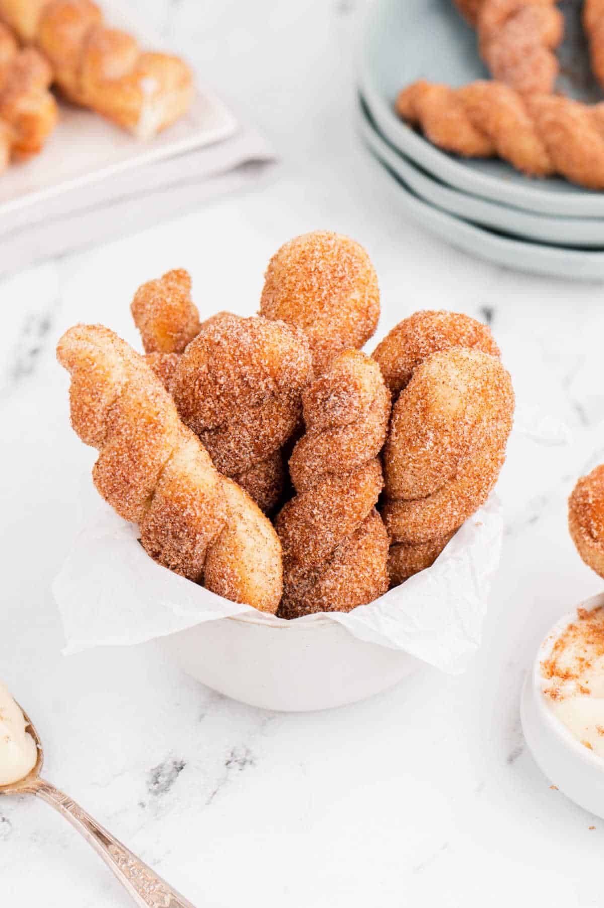 Air fryer cinnamon twists in a white bowl.